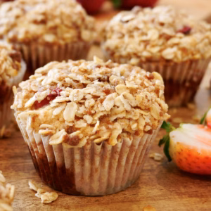 Bakery-style vegan strawberry muffins with oat crumble topping on a wire rack