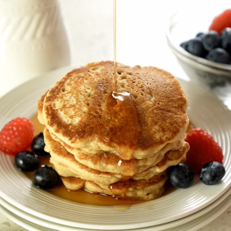 Stack of soft and fluffy vegan oat pancakes with golden edges